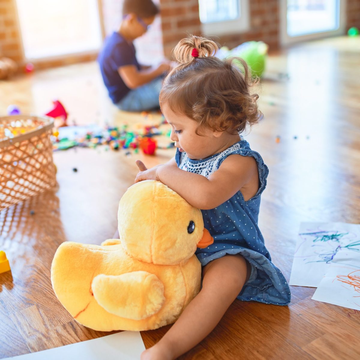 Adorable toddlers smiling happy. Sitting on the floor playing around lots of toys at kindergarten